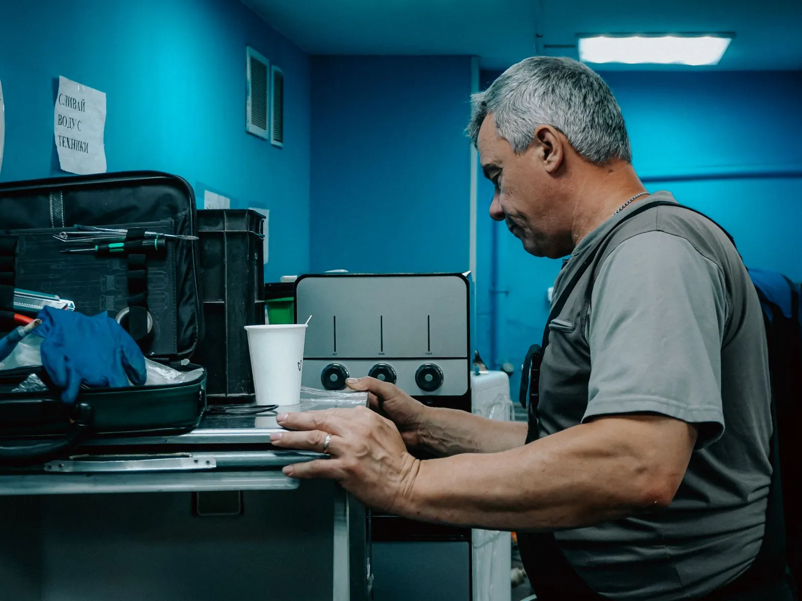 Técnico consertando um eletrodoméstico na bancada da oficina