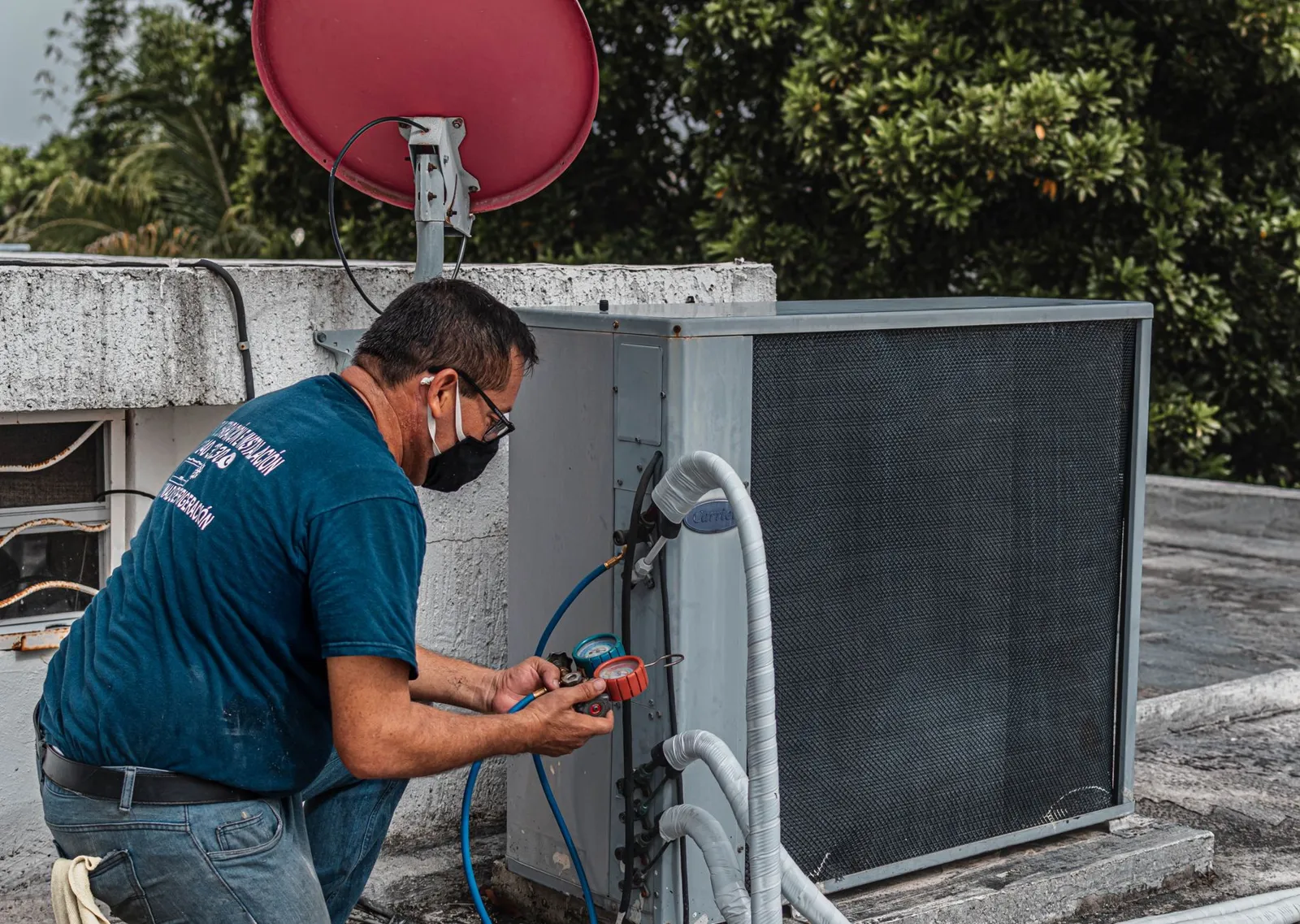 Técnico fazendo manutenção na condensadora de um ar-condicionado